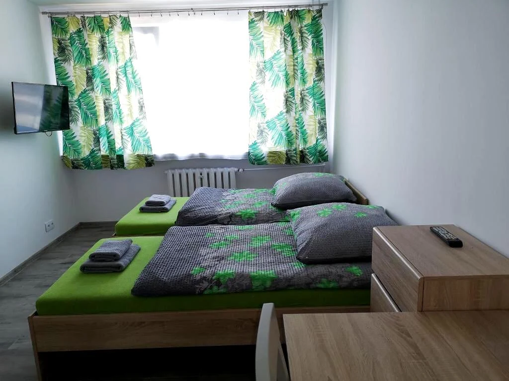 Pokój gościnny Fine Stay - jasne wnętrze z dwoma łóżkami, telewizorem i drewnianymi meblami